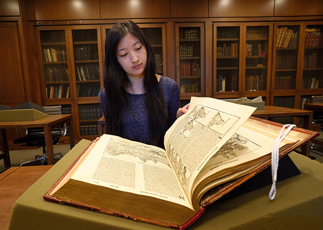 Researcher reading a larger book