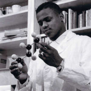 Black and white photo of man holding a scientific instrument