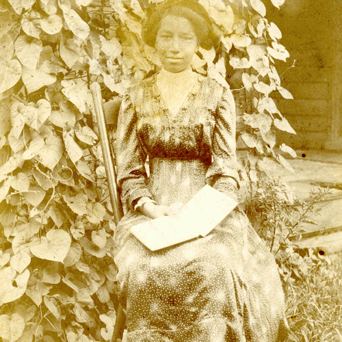 Vintage photograph of seated African American woman holding open book