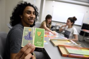 student holding up game pieces