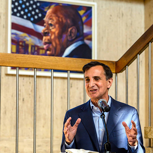 Ron Daniels standing in front of Elijah Cummins portrait