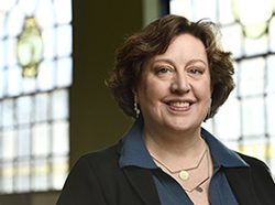 Headshot of Elisabeth M. Long in front of stained glass windows