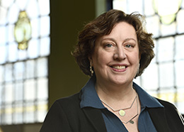 Headshot of Elisabeth M. Long in front of stained glass windows