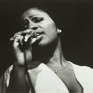black and white photograph detail of Ethel Ennis singing with microphone