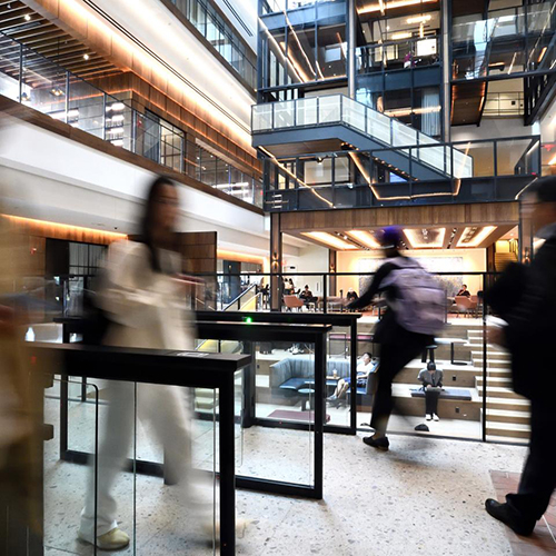 interior view of building with glass, metal, and people walking