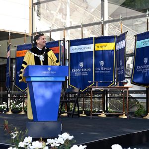 Johns Hopkins President Ronald J. Daniels standing at a blue podium