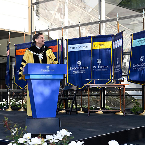 Johns Hopkins President Ronald J. Daniels standing at a blue podium
