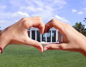 hands making heart shape around a building